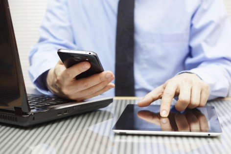 businessman is working on tablet and using smart phone in office with laptop