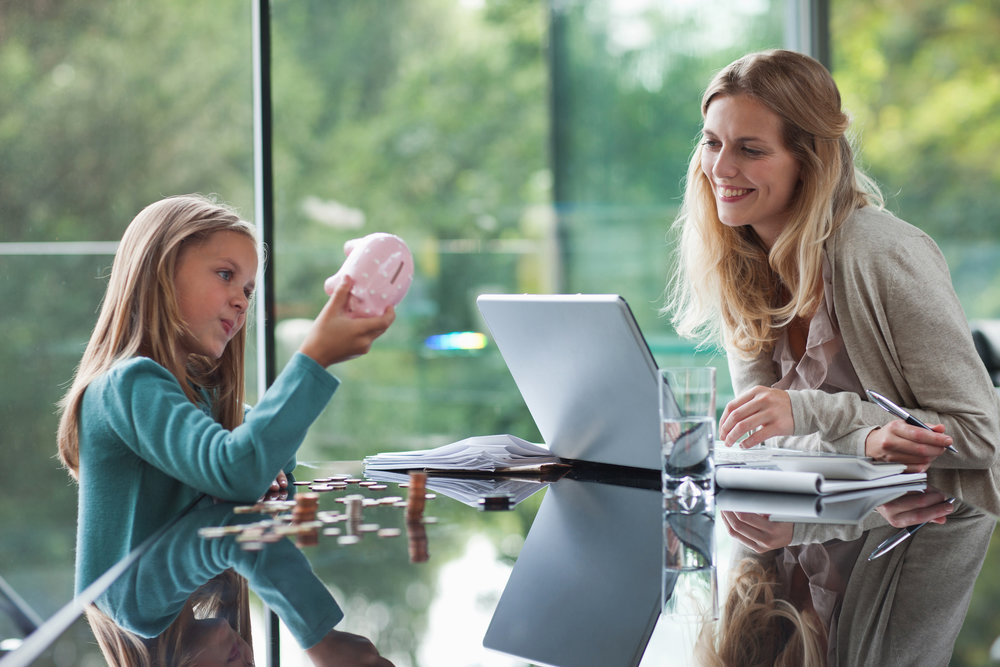 Mother watching daughter count coins from piggy bank