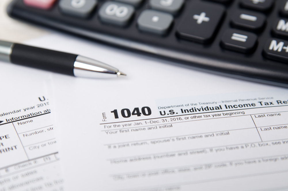 US tax form 1040 with pen and calculator. tax form law document usa white mathematics business concept