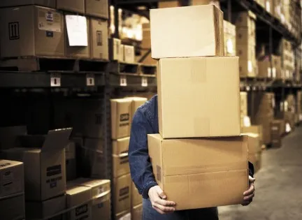 Manager working on computer in the warehouse.