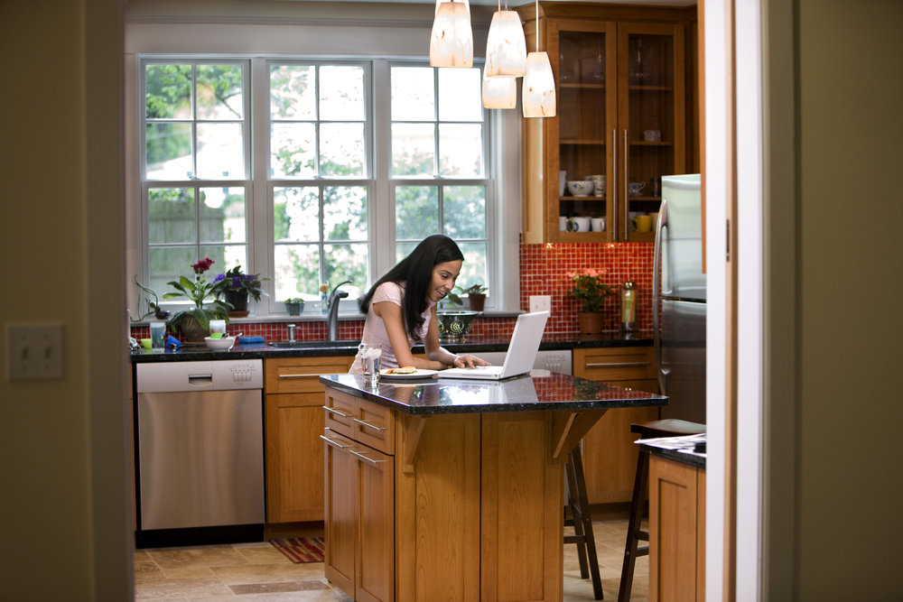 Woman in kitchen on laptop
