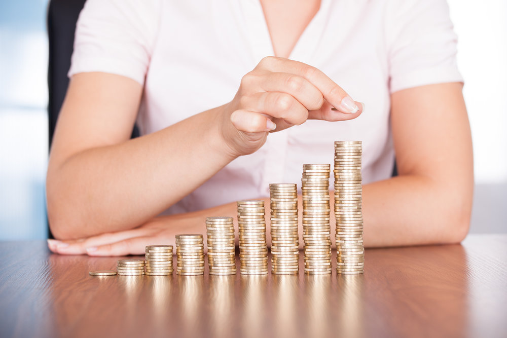 Close-up Of Businesswoman Stacking Gold Coins On Increasing Coins