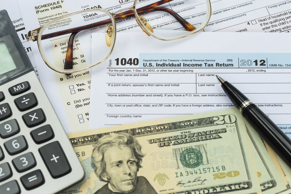Tax form with pen, calculator, dollar banknote , and glasses taxation concept